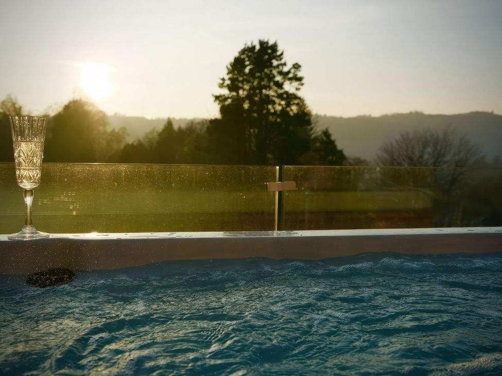 A hot tub with a glass next to it during sunset at Midways in Windermere