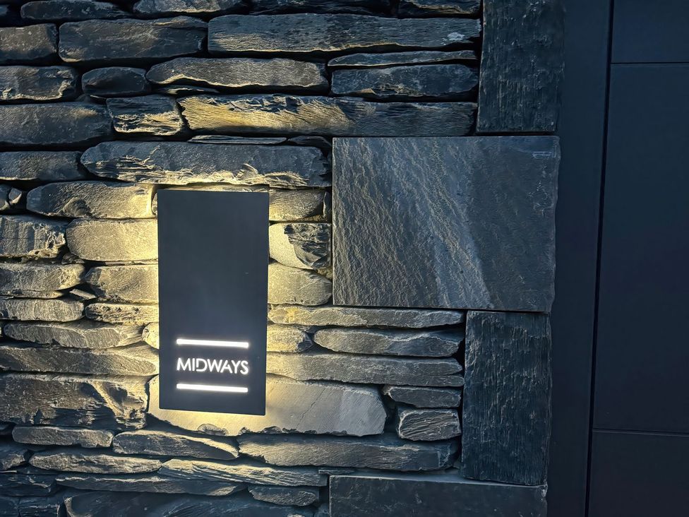 A wall with a lit sign at Midways in Windermere