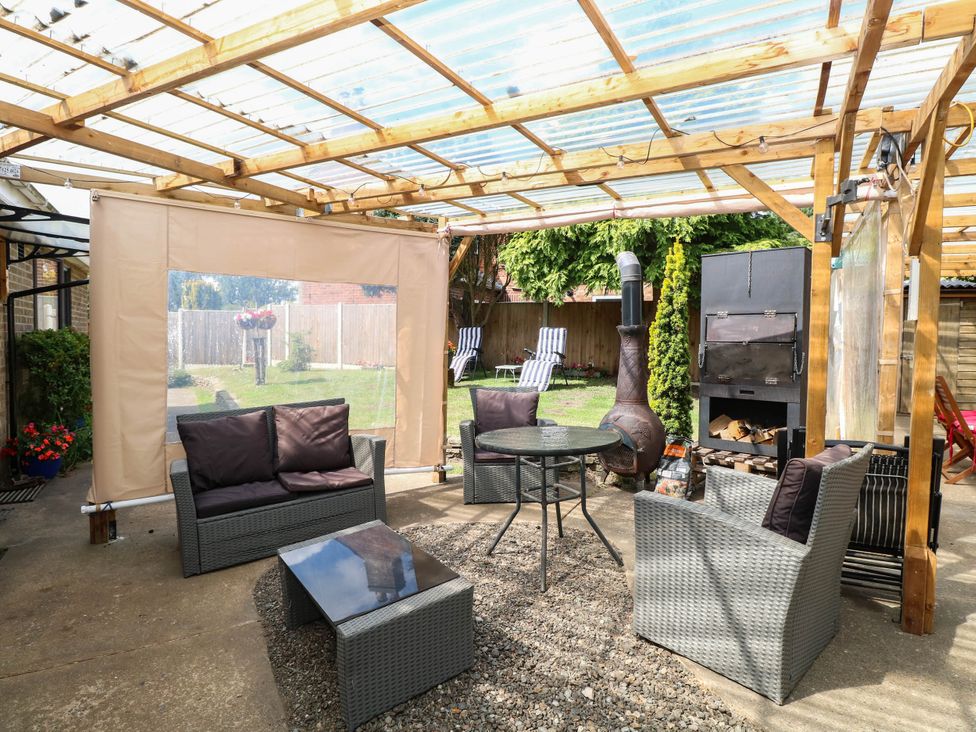 An outdoor living area with seating and a table at The Bungalow in Burgh Castle