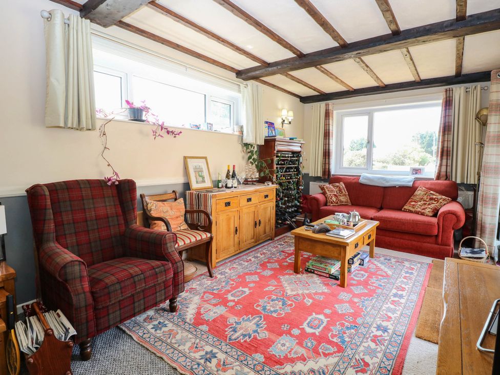 A living room with a sofa and armchair at The Bungalow in Burgh Castle