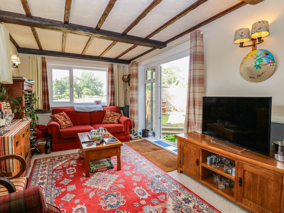 A living room with a couch and television at The Bungalow in Burgh Castle
