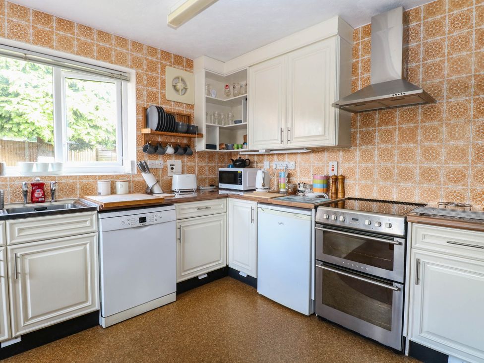 A kitchen with appliances and storage at The Bungalow in Burgh Castle