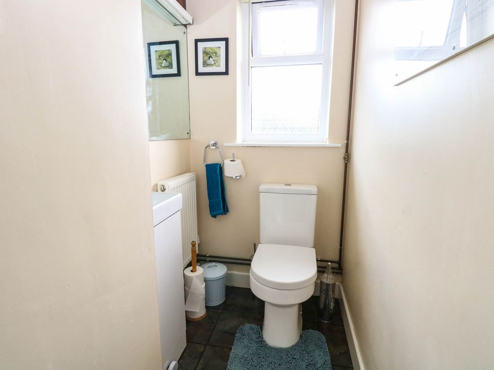 A bathroom with a toilet and washing machine at The Bungalow in Burgh Castle
