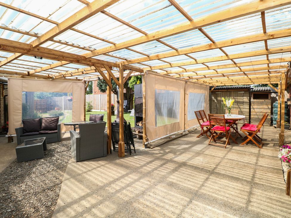 An outdoor area with seating and a dining table at The Bungalow in Burgh Castle