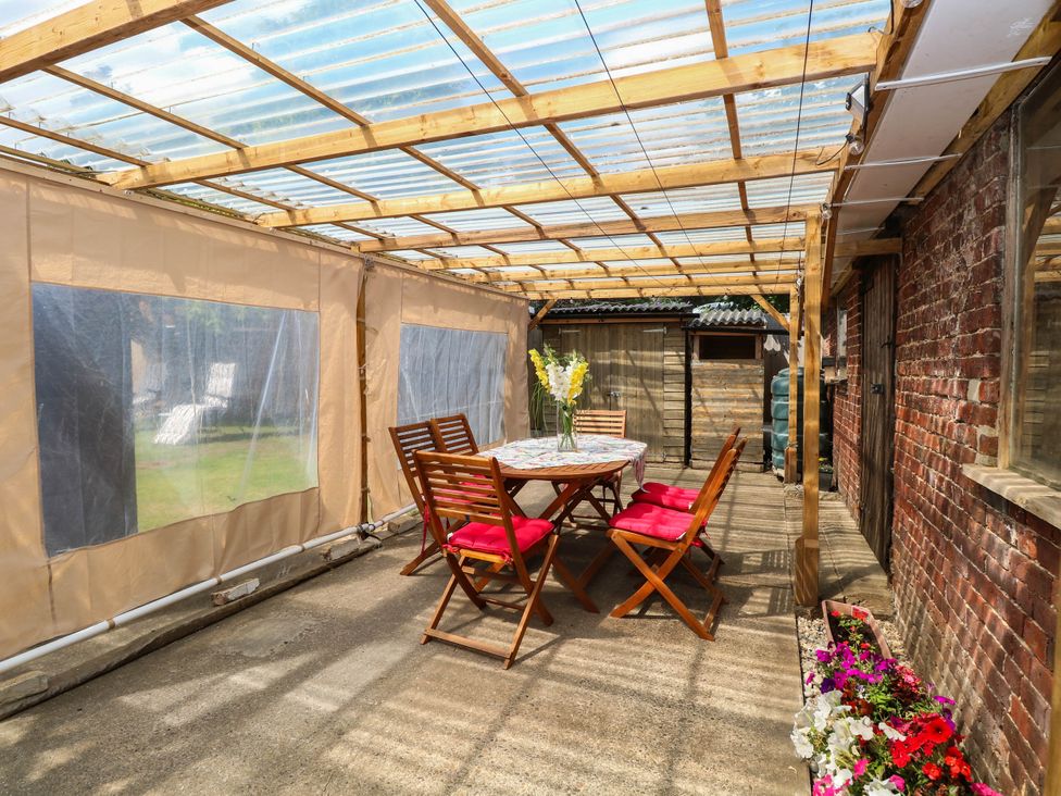 A conservatory with a table and chairs at The Bungalow in Burgh Castle