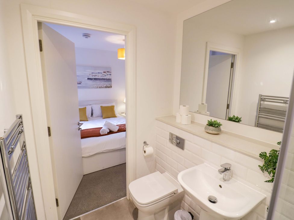 A bathroom with a sink and toilet leading to a bedroom at Park-View Nook in Birmingham