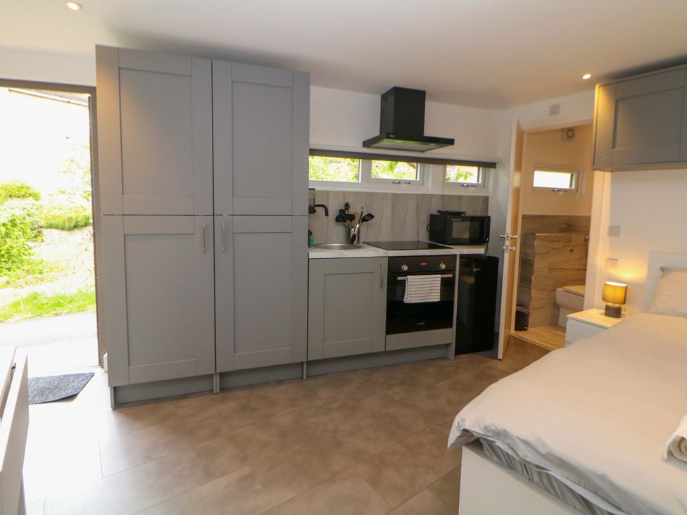 A kitchen with appliances and a bed at Dore Cabin Sheffield
