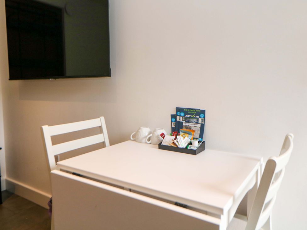 A dining room with a table, chairs, and snacks at Dore Cabin Sheffield
