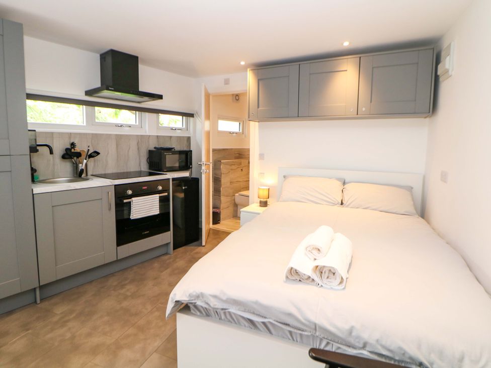 A studio with bed and kitchen appliances at Dore Cabin Sheffield