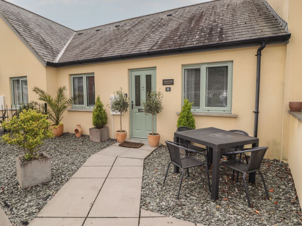 A table and chairs in a gravel area at Cornstore Cottage in Pembroke