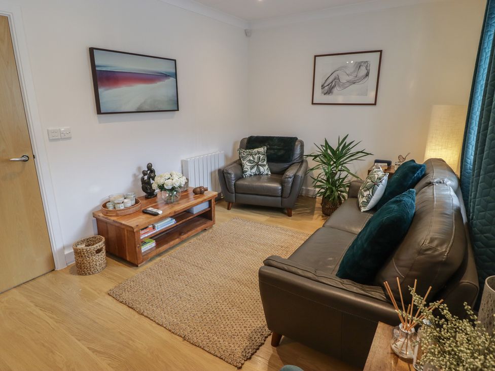A living room with a sofa and coffee table at Cornstore Cottage in Pembroke