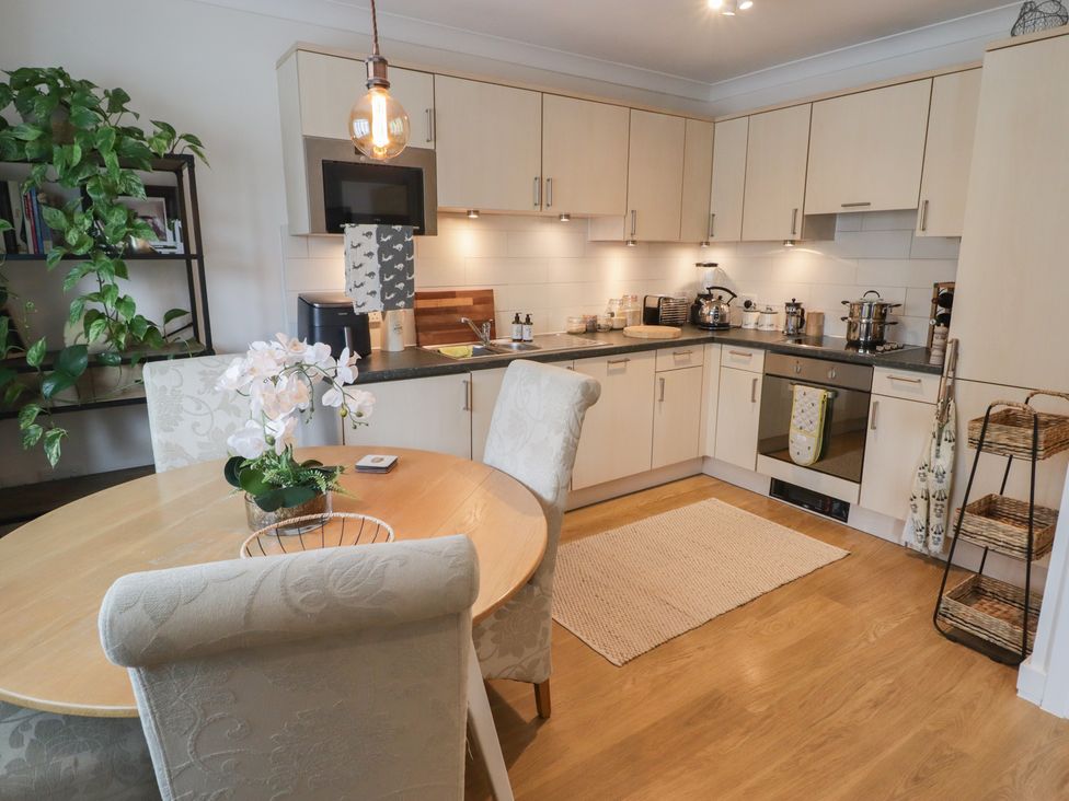 A kitchen with a dining table and chairs at Cornstore Cottage in Pembroke