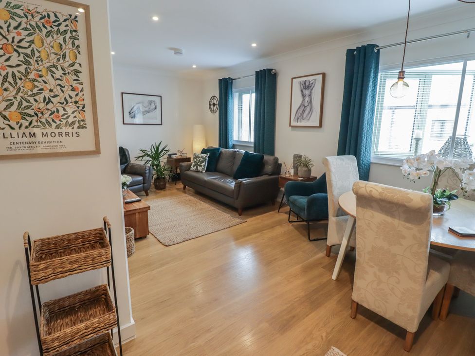 A living room with a sofa and chairs at Cornstore Cottage in Pembroke