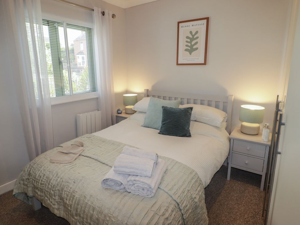 A bedroom with a bed and window at Cornstore Cottage in Pembroke
