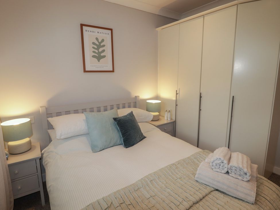 A bedroom with a bed and wardrobe at Cornstore Cottage in Pembroke