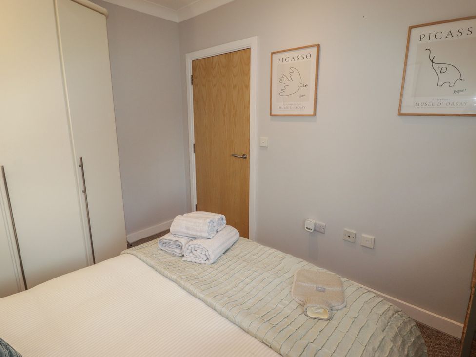 A bedroom with towels on the bed at Cornstore Cottage in Pembroke