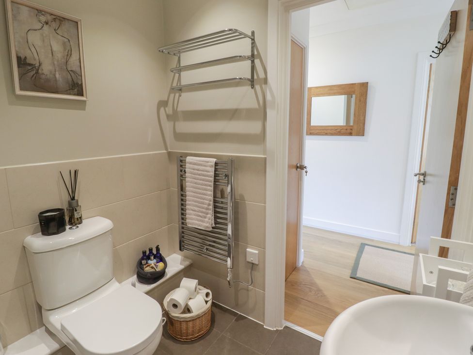 A bathroom with a toilet and towel rack at Cornstore Cottage, Pembroke