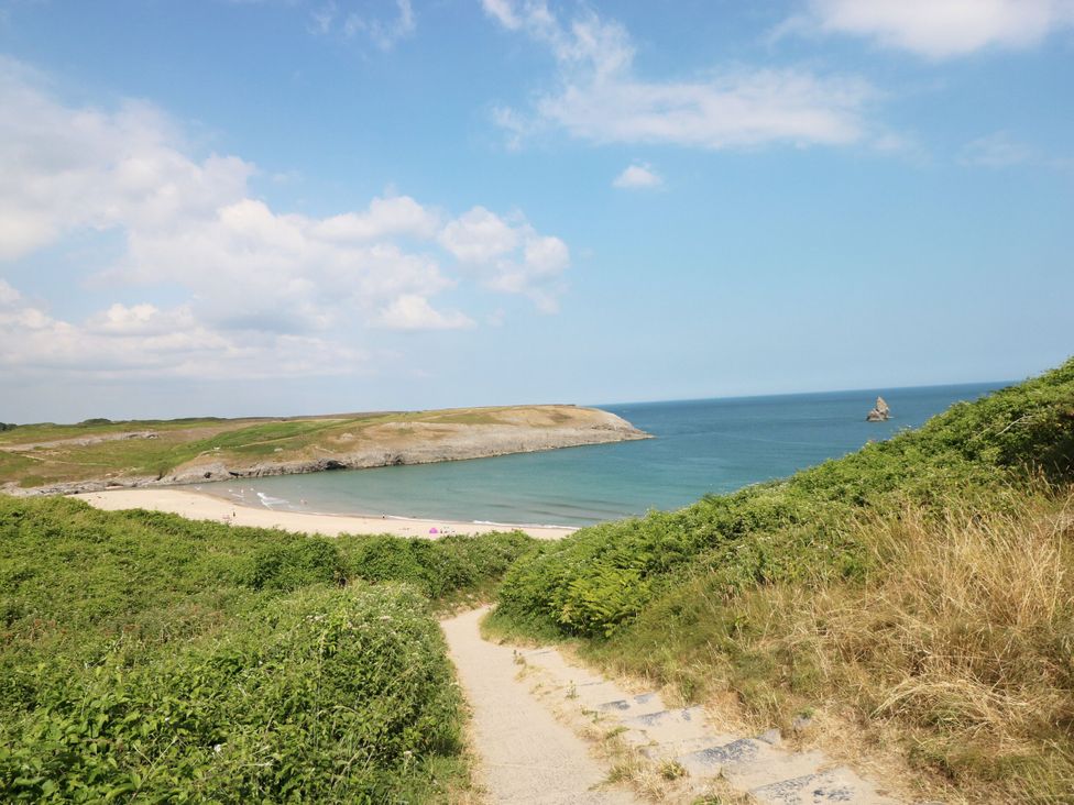 A beach view with steps leading down to sand at Cornstore Cottage Pembroke