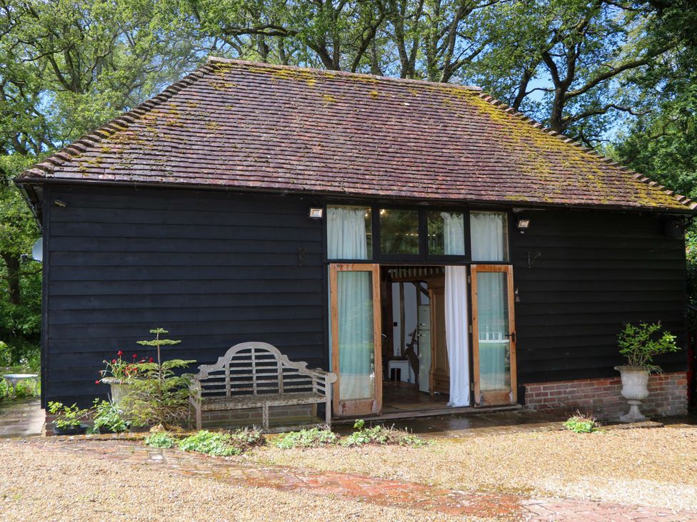 A building with a bench and open doors at Petworth Barn in Petworth