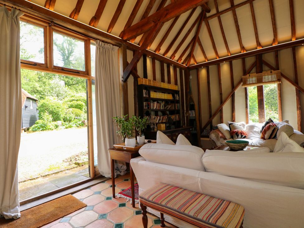 A living room with a sofa and bookshelf at Petworth Barn in Petworth