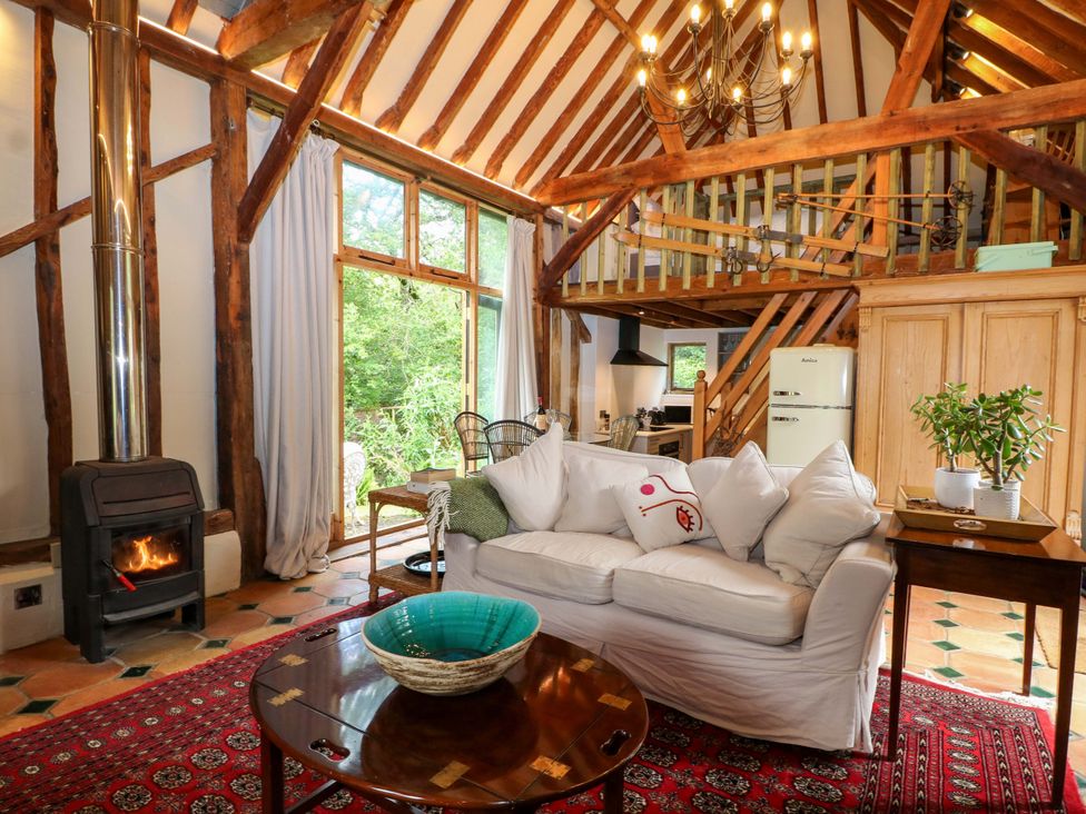 A living room with a fireplace and sofa at Petworth Barn in Petworth