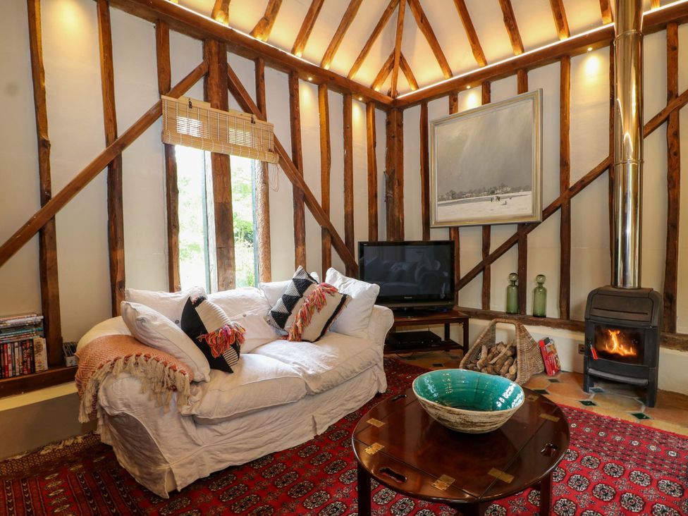A living room with a sofa and television at Petworth Barn in Petworth
