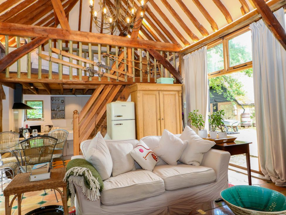 A living room with a sofa and dining area at Petworth Barn in Petworth
