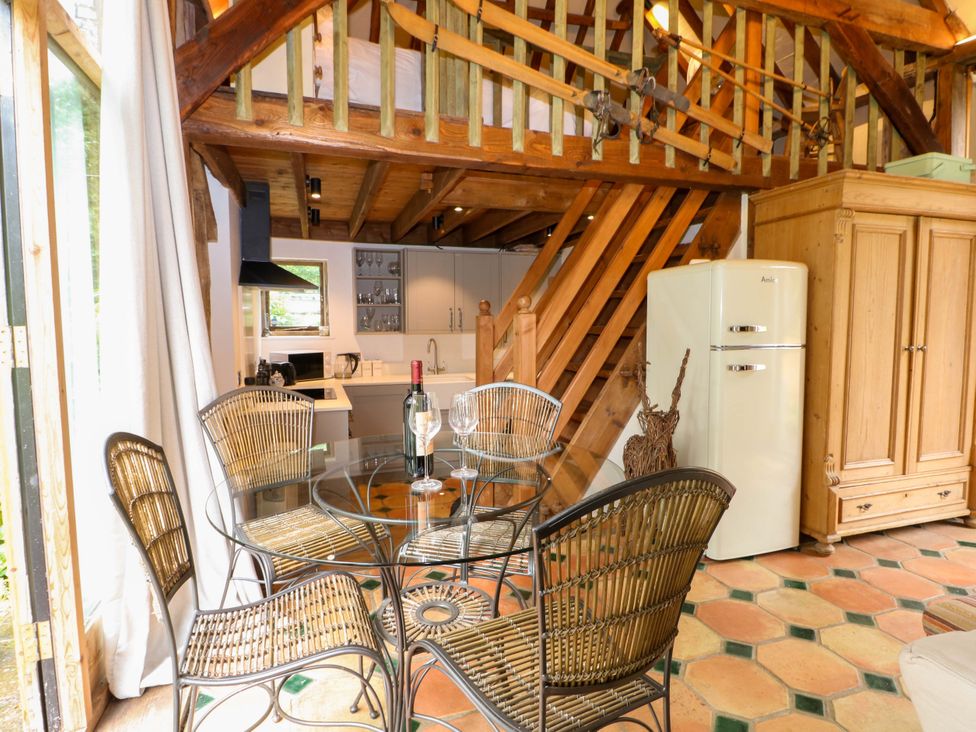 A kitchen with a glass table and chairs at Petworth Barn in Petworth