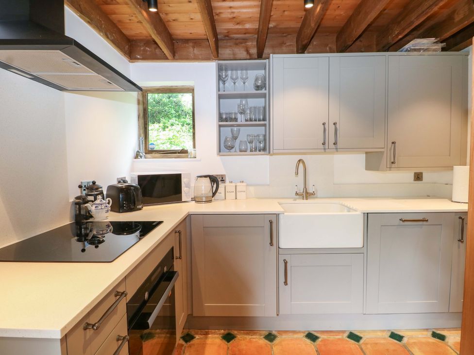 A kitchen with cabinets and a sink at Petworth Barn in Petworth