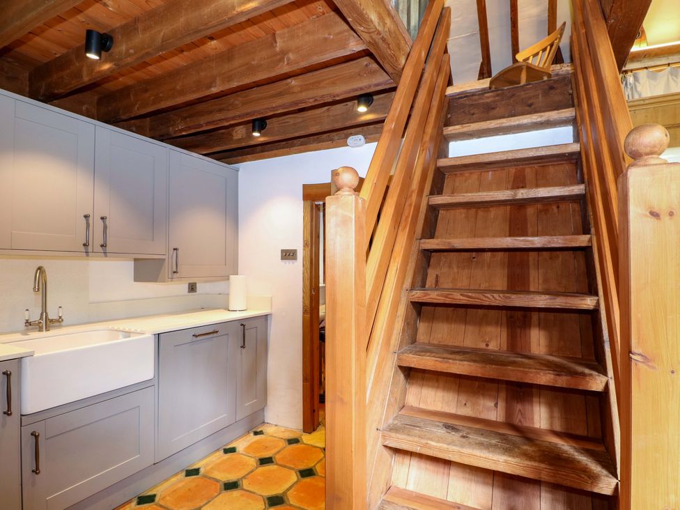 A kitchen with cabinets and stairs at Petworth Barn in Petworth
