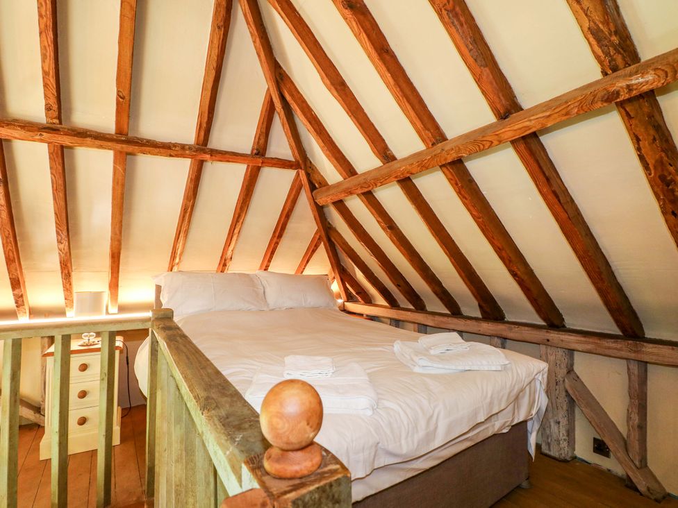 A bedroom with a bed and wooden beams at Petworth Barn in Petworth
