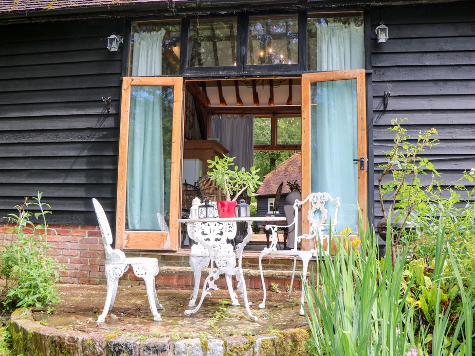 An outdoor seating area with chairs and a table at Petworth Barn in Petworth