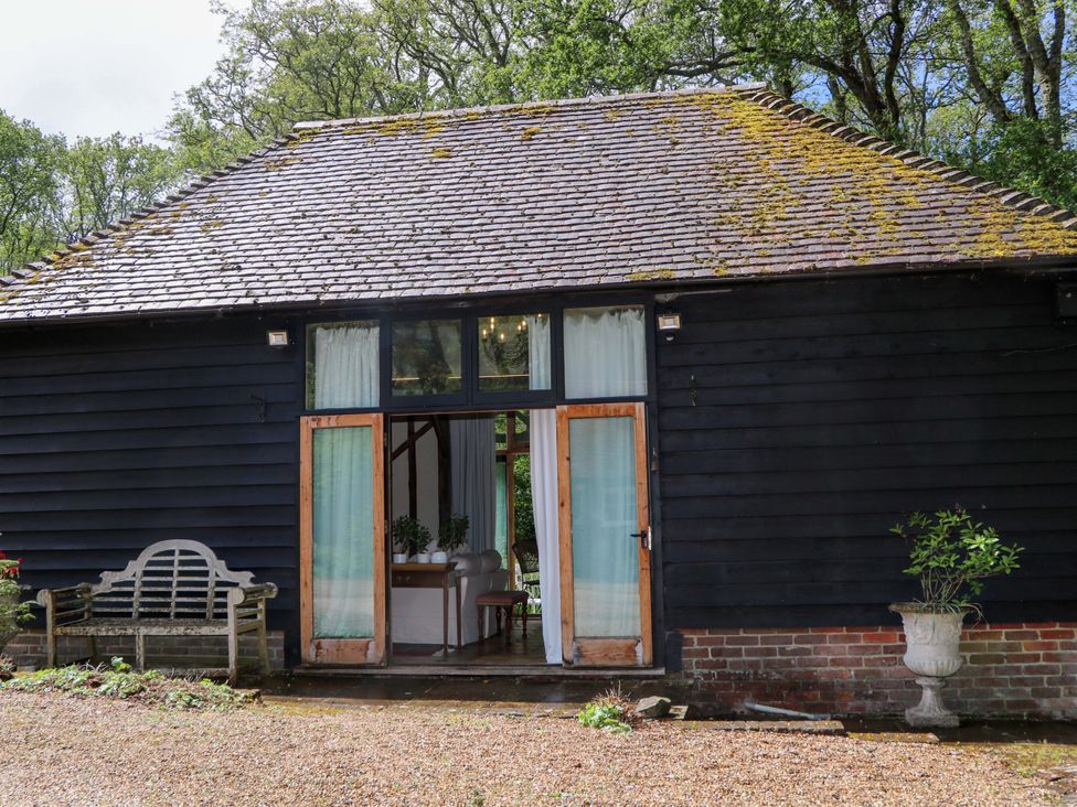 A building with a bench and flower pot at Petworth Barn in Petworth