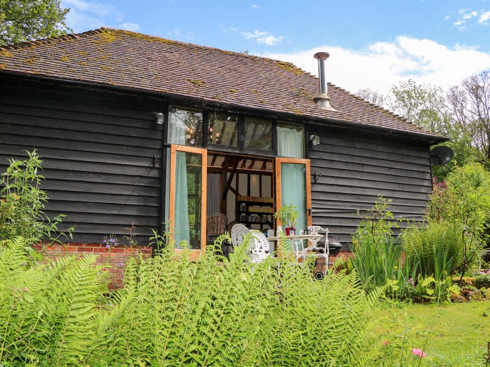 A view of a building with door and window surrounded by plants at Petworth Barn in Petworth