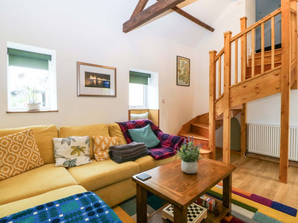 A living room with stairs and a sofa at Ty Loti