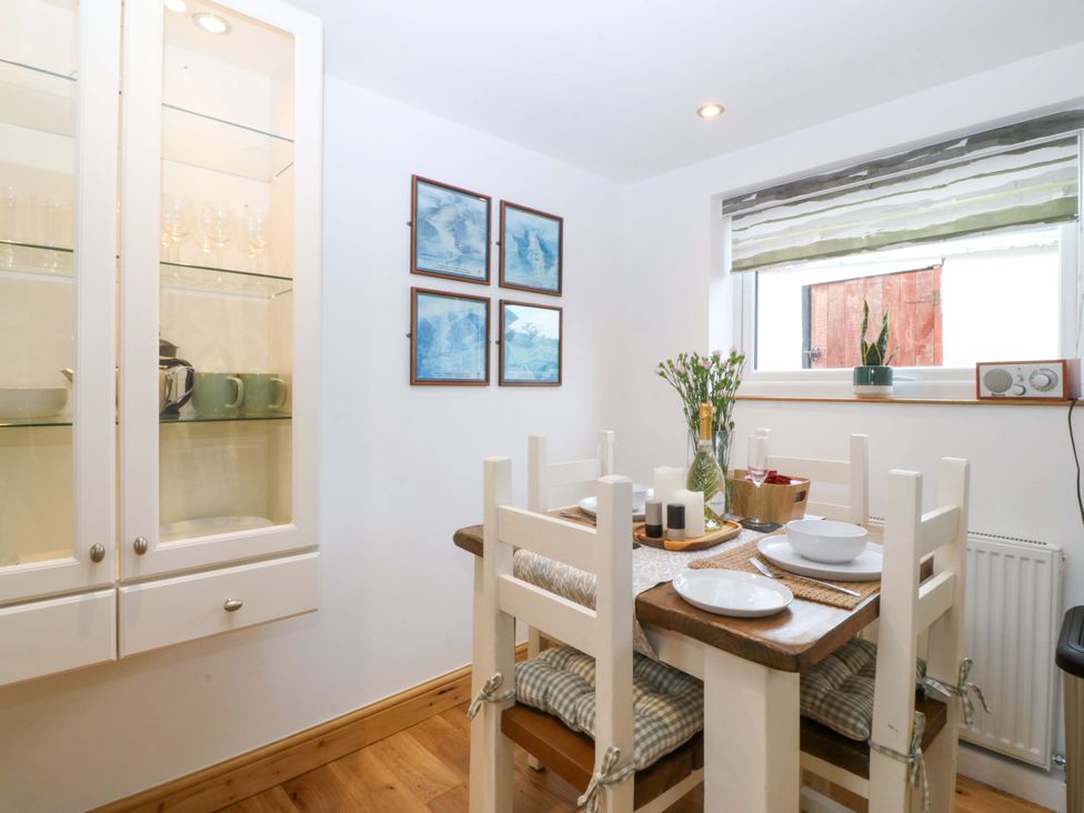 A dining room with a table and four chairs at Ty Loti