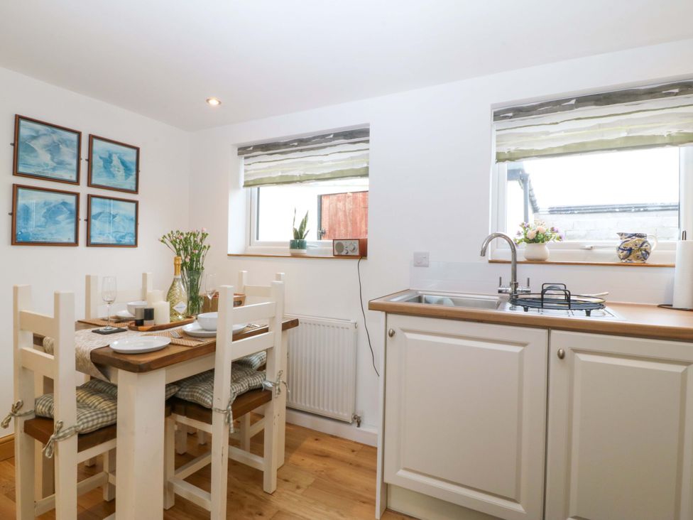 A kitchen with a dining table and tableware at Ty Loti