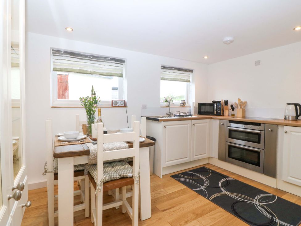 A kitchen with a table and chairs at Ty Loti