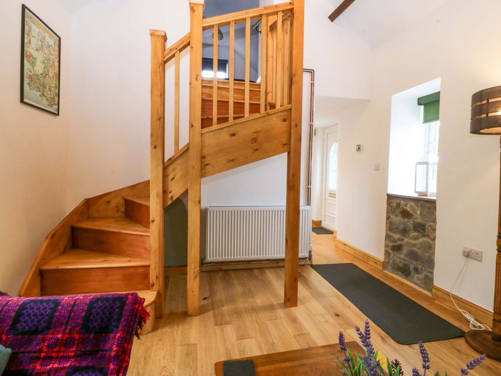 A hallway with a staircase and a radiator at Ty Loti 
