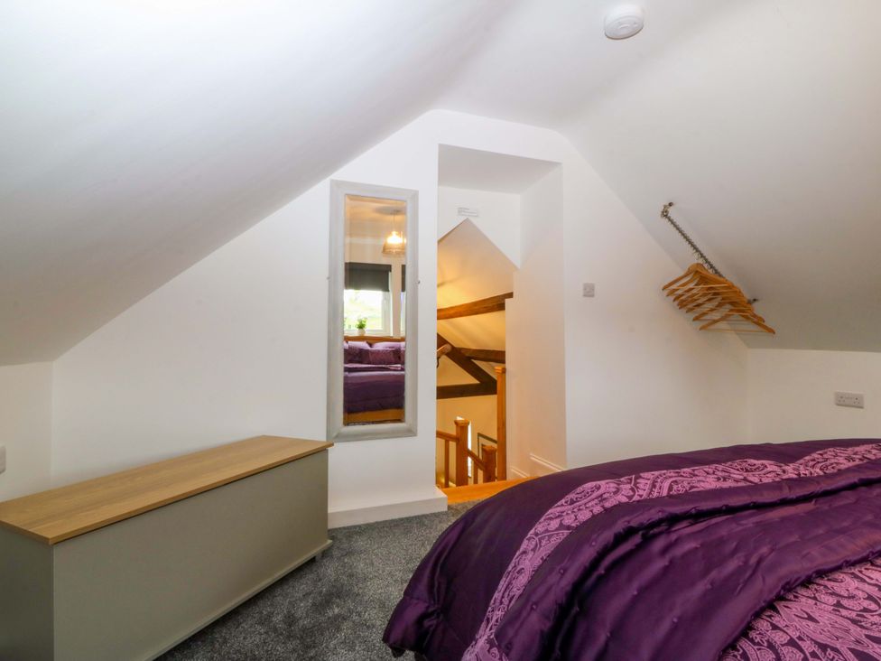 A bedroom with a bed and a mirror at Ty Loti