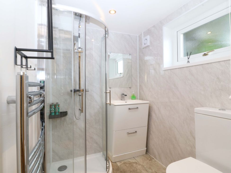 A bathroom featuring a shower, sink, and toilet at Ty Loti