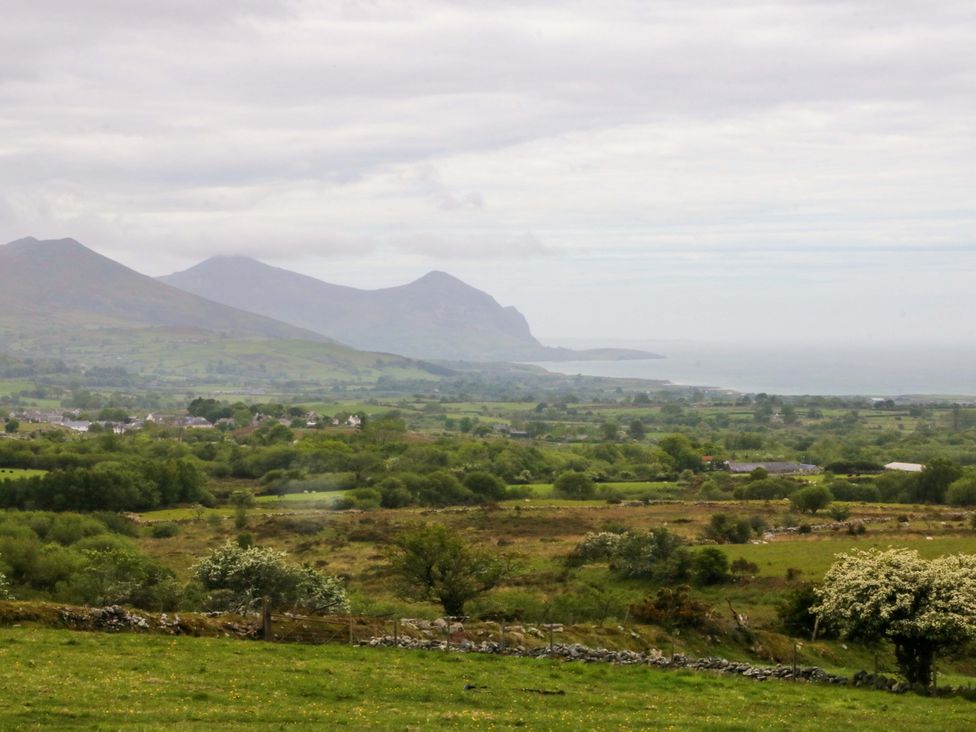 A landscape view with mountains and ocean at Ty Loti