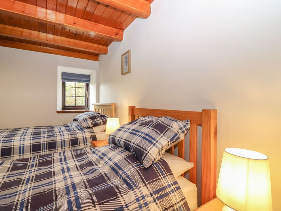 A bedroom with two beds and a window at Viola Cottage Fraserburgh