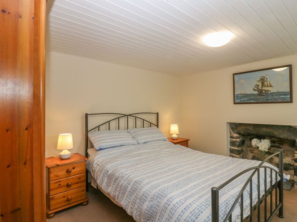 A bedroom with a bed and nightstand at Viola Cottage in Fraserburgh