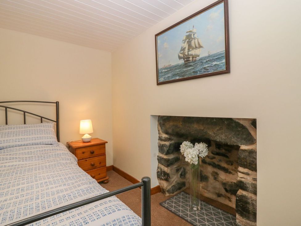 A bedroom with a bed and a lamp at Viola Cottage in Fraserburgh