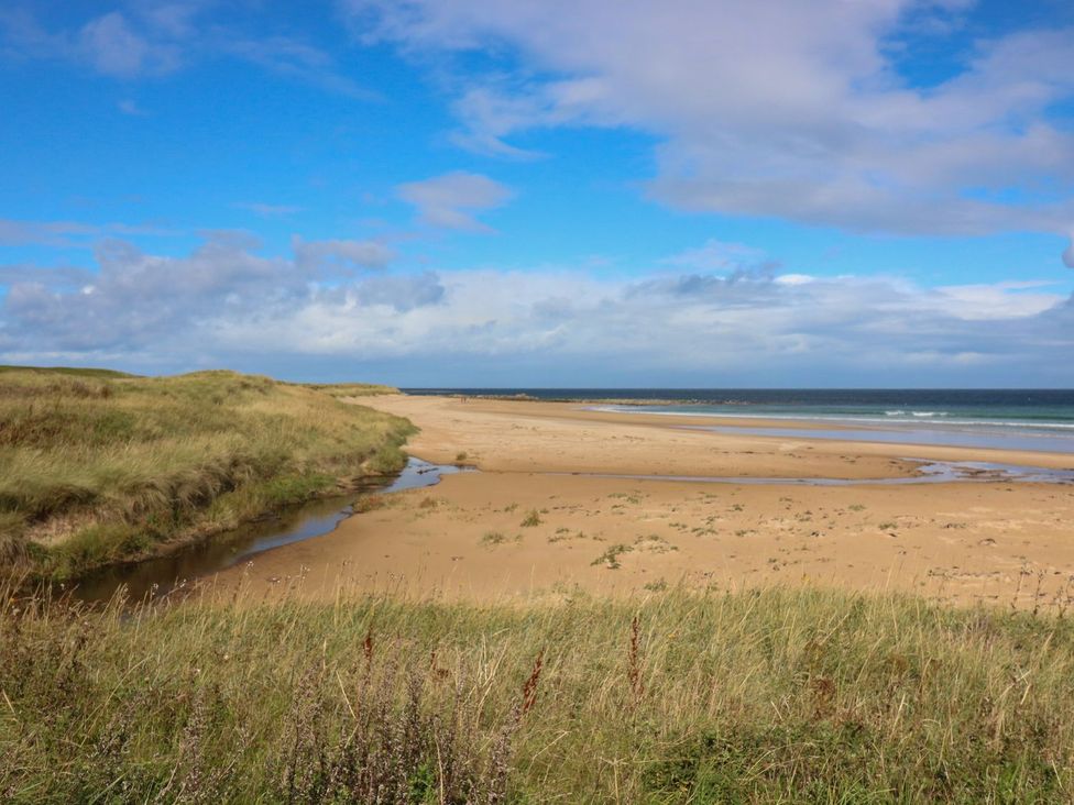 A beach landscape with sand and water at Viola Cottage in Fraserburgh