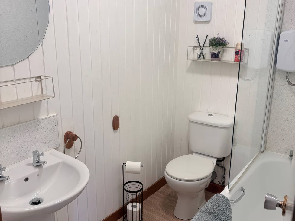 A bathroom with a sink, toilet, and shower at Viola Cottage in St Combs near Fraserburgh
