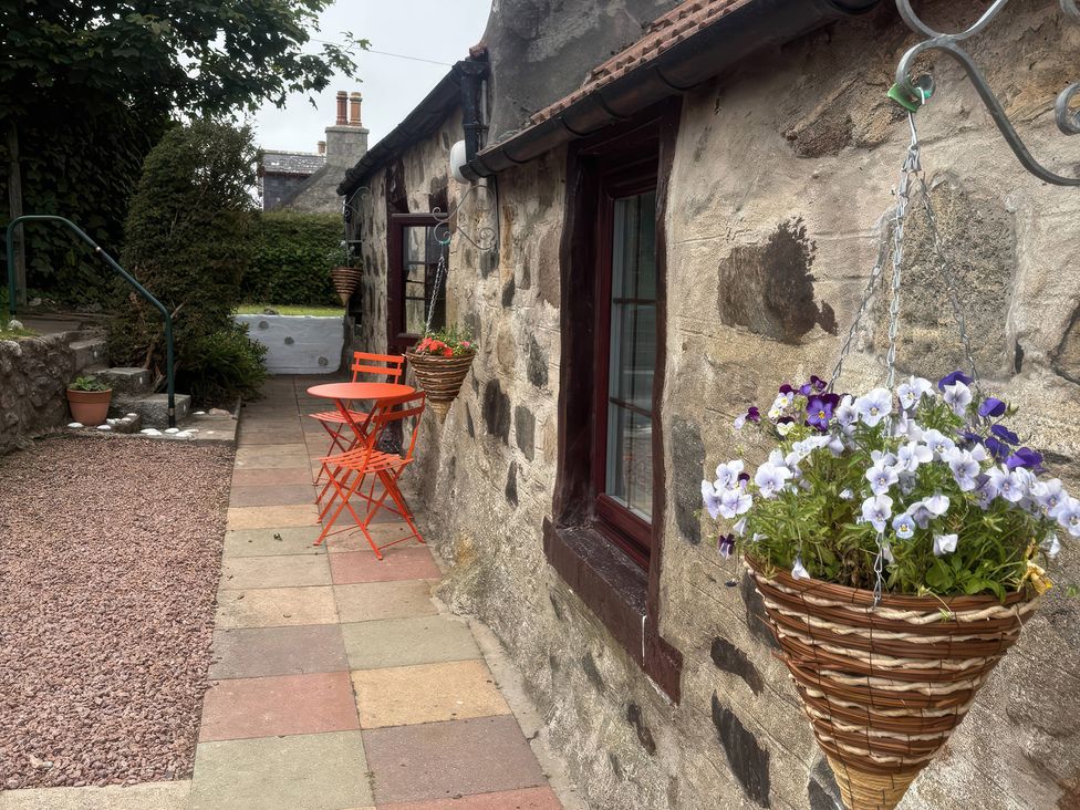 An outdoor seating area with a table and chairs at Viola Cottage St Combs near Fraserburgh