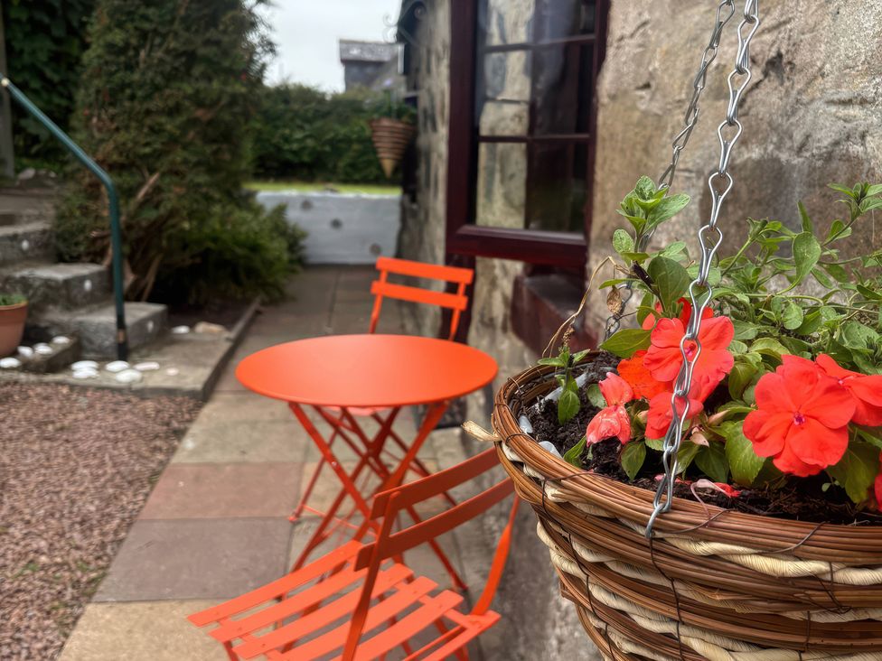 An outdoor area with an orange table and chairs at Viola Cottage St Combs near Fraserburgh
