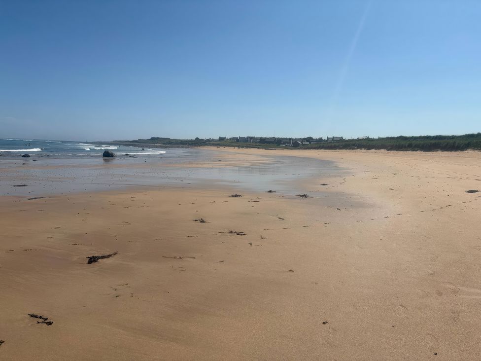 A beach with sand and waves at Viola Cottage in St Combs near Fraserburgh